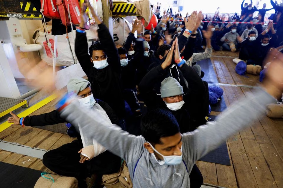 Migrants react as they wait to disembark the Geo Barents rescue ship, operated by Medecins Sans Frontieres, 26 March, 2023